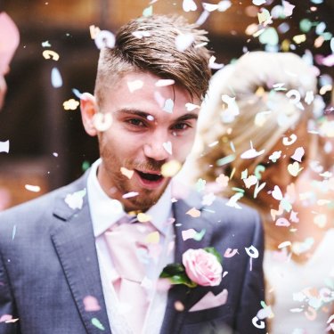 カラフルな紙吹雪で祝福される新郎新婦