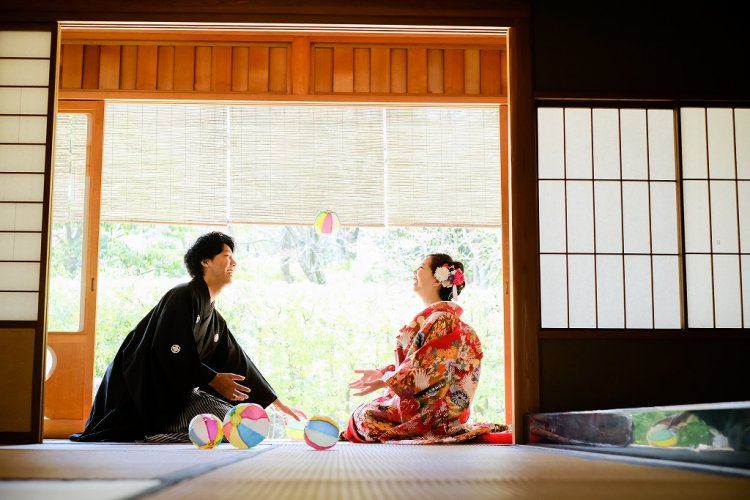 縁側で紙風船で遊ぶ新郎と新婦様