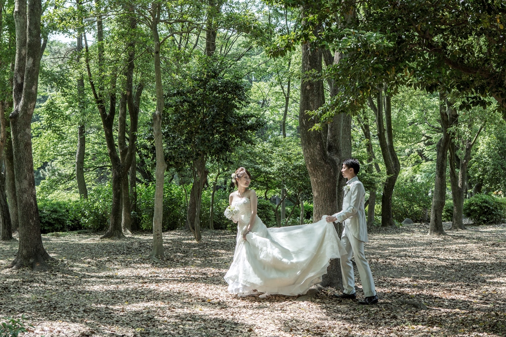 名城公園の緑の中をウェディングドレスとタキシードを着てお散歩
