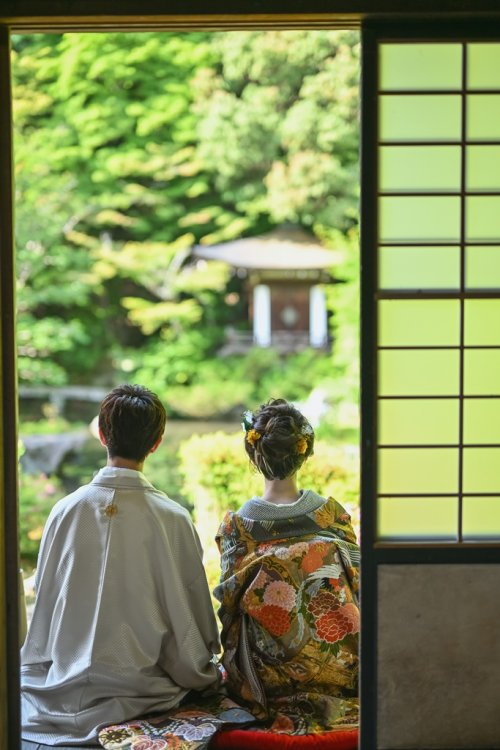 縁側からの眺めを楽しむ夫婦の後ろ姿