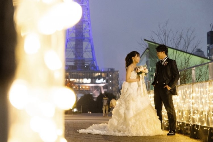 キラキラ輝くイルミネーションの中で見つめ合う新郎新婦