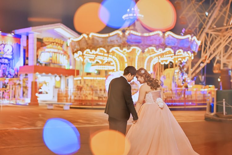 キラキラした光の中でおでこを合わせる新郎新婦