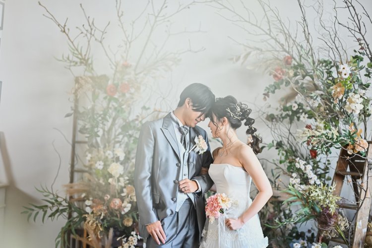 ドライフラワーの前でおでこを合わせる新郎新婦