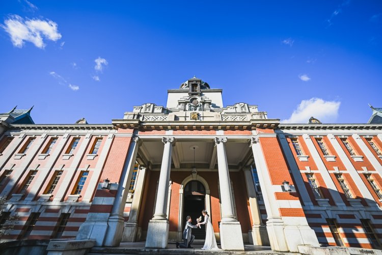 青空のもと市政資料館入口でプロポーズ