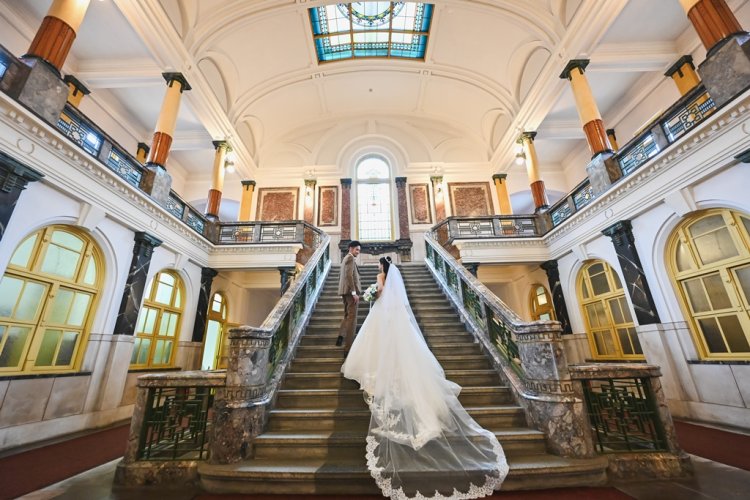 大階段で手を取り見つめ合う新郎新婦