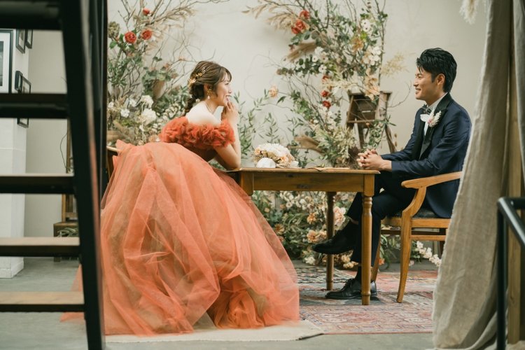 テーブルをはさみ椅子に向かい合って座る新郎新婦