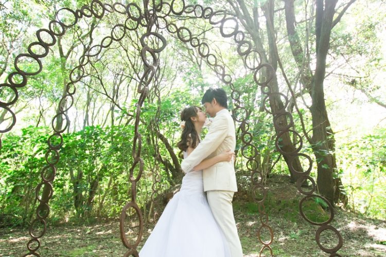 緑に囲まれながら抱き合う新郎新婦