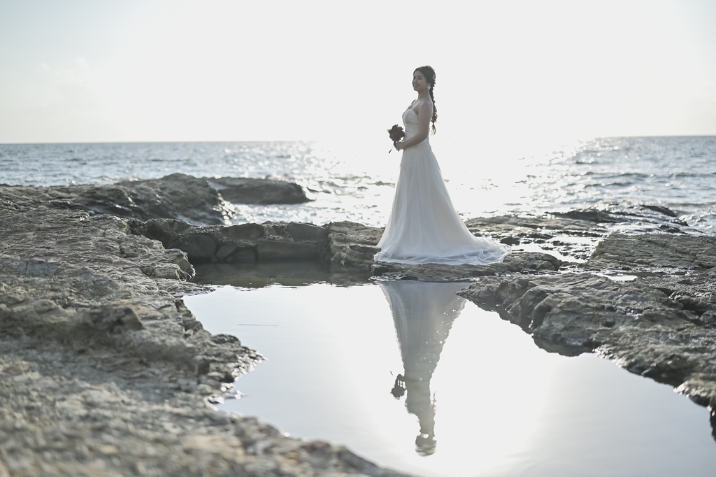 海辺でブーケを手にポーズをとる新婦