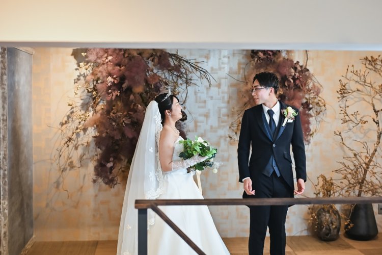 振り返ってドレス姿の新婦を見つめる新郎