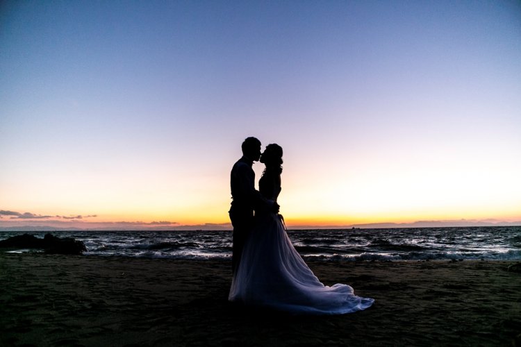 綺麗なサンセットで抱き合う新郎新婦シルエット