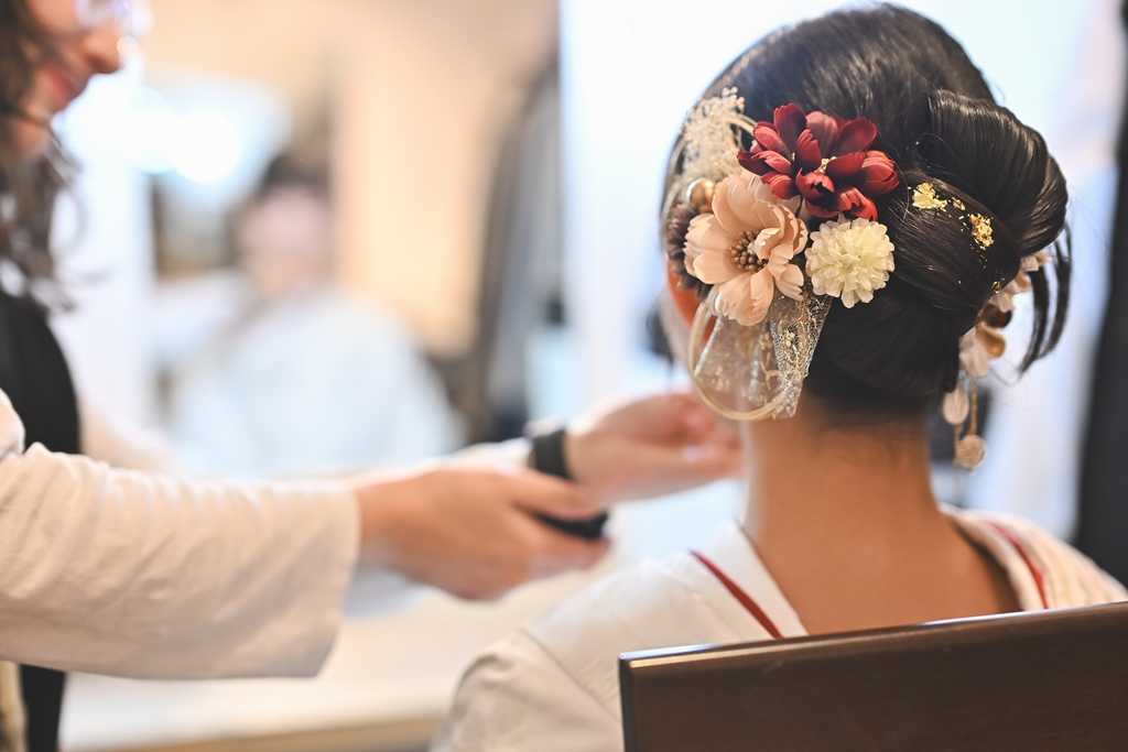 花嫁がヘアメイク中に笑顔でリラックスしているイメージ