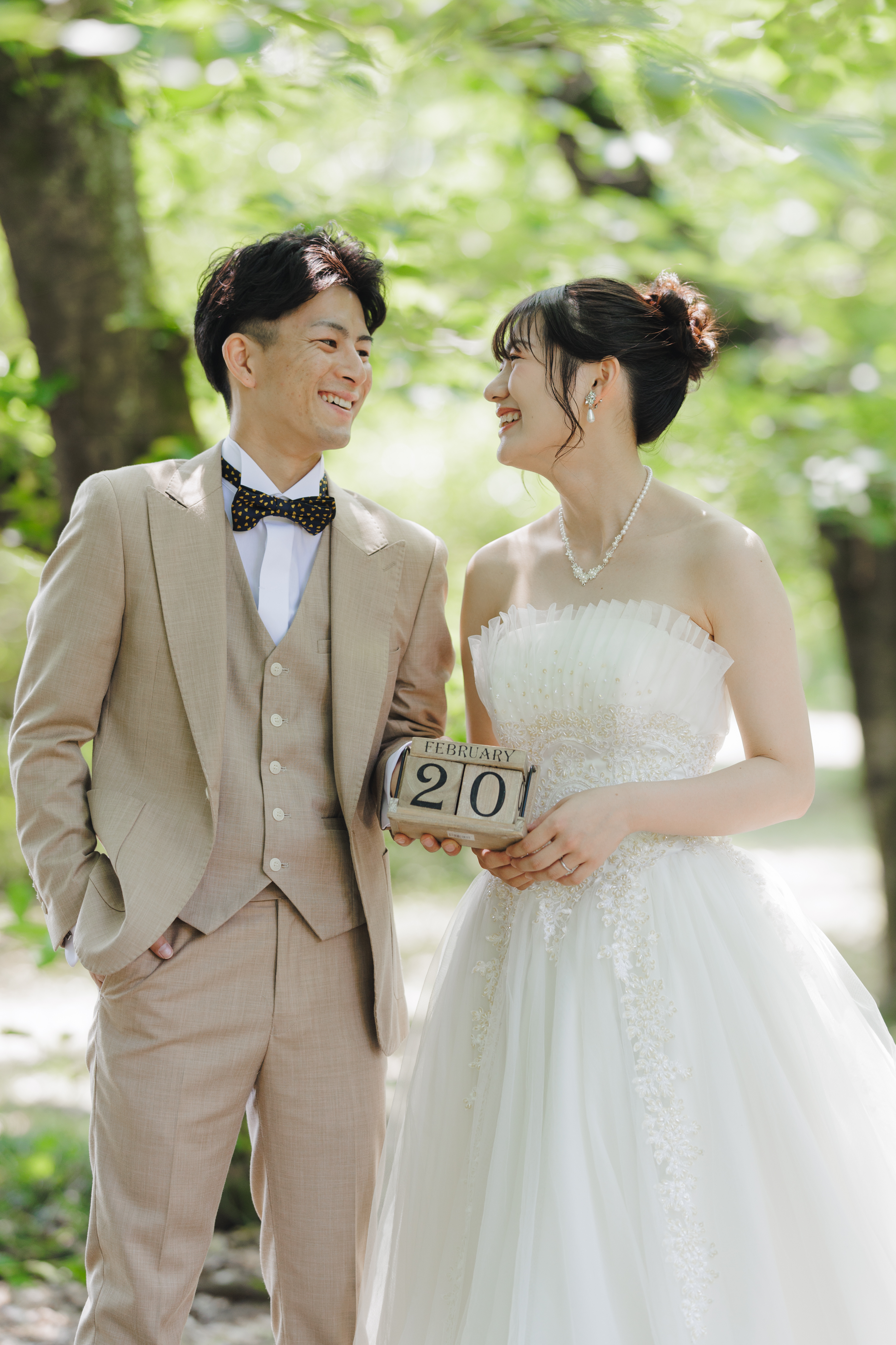夏の緑豊かなロケーションでドレスを着て撮影するカップル