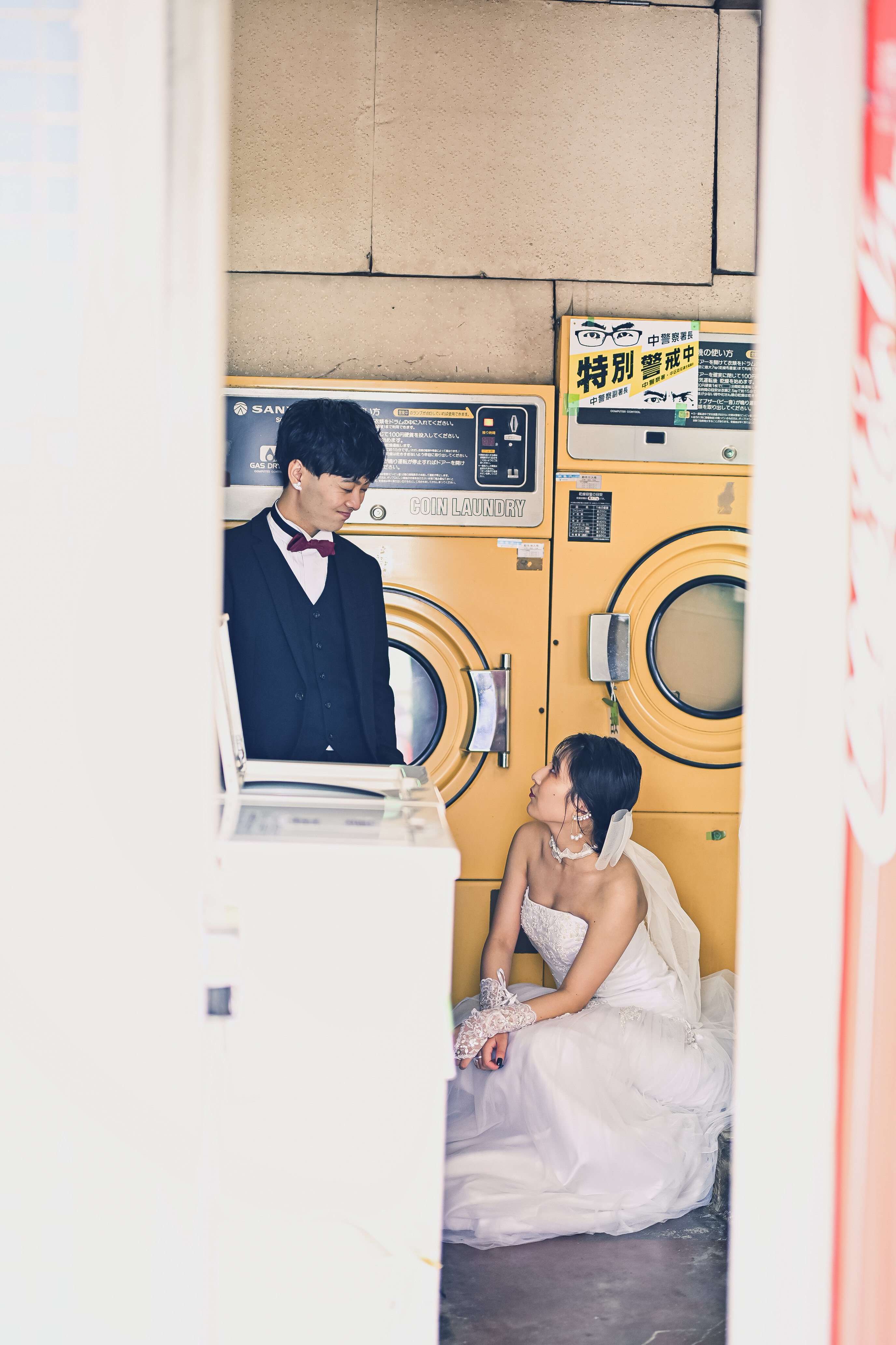 大須商店街のカラフルなアーケードを背景にウェディングドレス姿で佇むカップルの前撮り写真