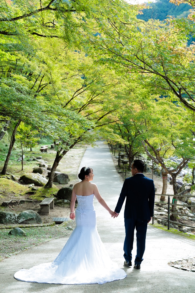 新緑を背景にドレス姿で振り返るポーズの新婦