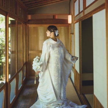 白鳥庭園の数寄屋の廊下で、ブーケを持って振り返る白無垢の花嫁の後ろ姿の和装前撮り
